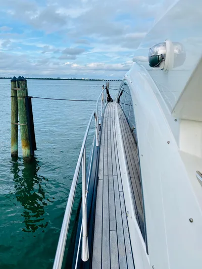 Essence Yacht Photos Pics Side deck view of 2010 Sunseeker Predator 60 yacht docked by the water.