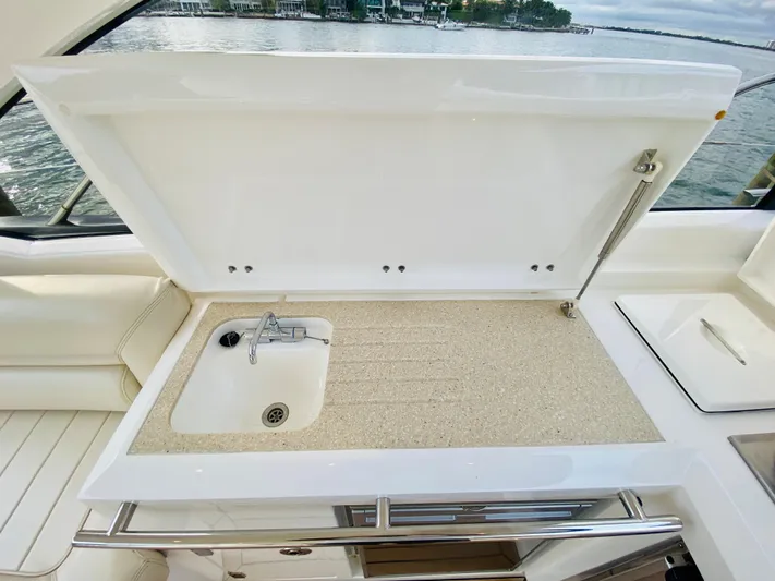 Essence Yacht Photos Pics Sunseeker Predator 60 2010 yacht sink and countertop with open lid, docked by the water.