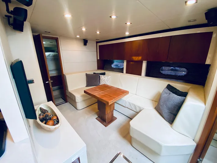 Essence Yacht Photos Pics Luxurious interior of 2010 Sunseeker Predator 60 yacht with white leather seating and wooden table.