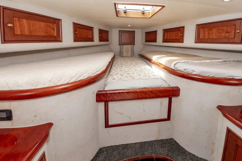Sea Horse Yacht Photos Pics 1994 Custom Carolina 43 Blackwell Convertible cabin with wooden cabinets and cozy bedding.