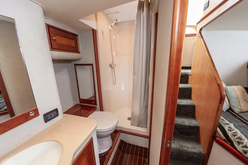 Sea Horse Yacht Photos Pics Bathroom interior of 1994 Custom Carolina 43 Blackwell Convertible yacht, featuring shower and wooden accents.