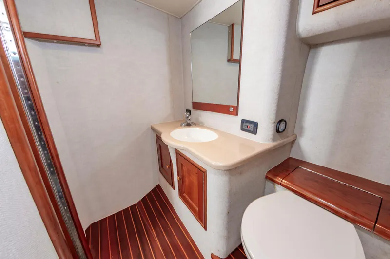 Sea Horse Yacht Photos Pics Bathroom interior of 1994 Custom Carolina 43 Blackwell Convertible yacht, featuring wood accents and modern fixtures.