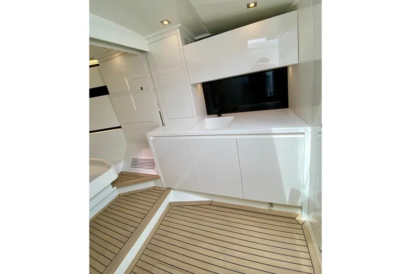  Yacht Photos Pics Modern interior of 2025 VanDutch 48 yacht with sleek cabinetry and wood flooring.