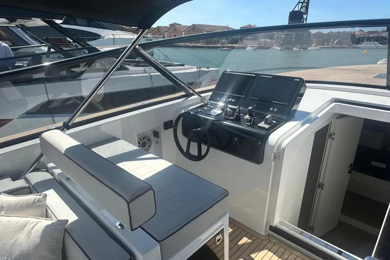  Yacht Photos Pics 2025 VanDutch 48 yacht cockpit with modern controls and seating, docked by the water.