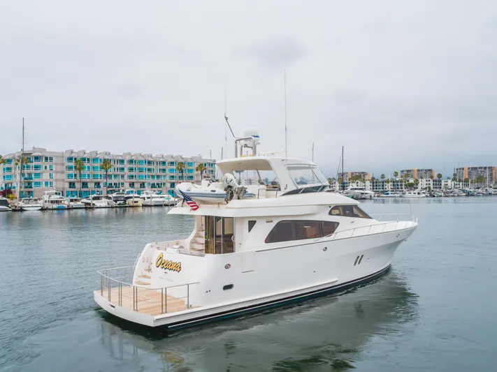 Oceana Yacht Photos Pics 2009 McKinna 60 Pilothouse yacht docked in marina, with modern waterfront buildings.