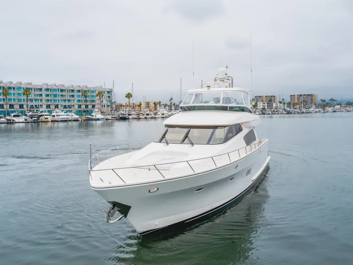 Oceana Yacht Photos Pics 2009 McKinna 60 Pilothouse yacht cruising in a marina with modern buildings in the background.
