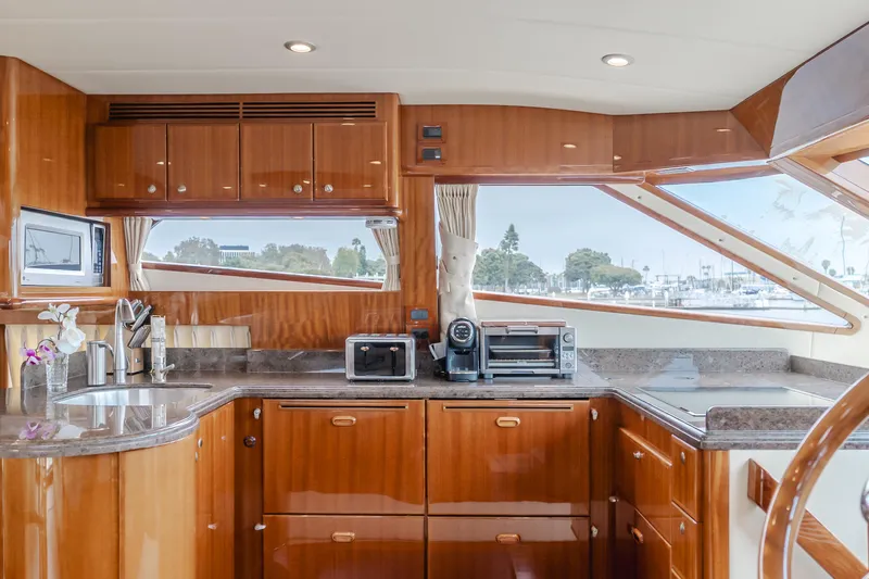 Oceana Yacht Photos Pics Luxurious kitchen interior of 2009 McKinna 60 Pilothouse yacht with wood cabinetry and modern appliances.
