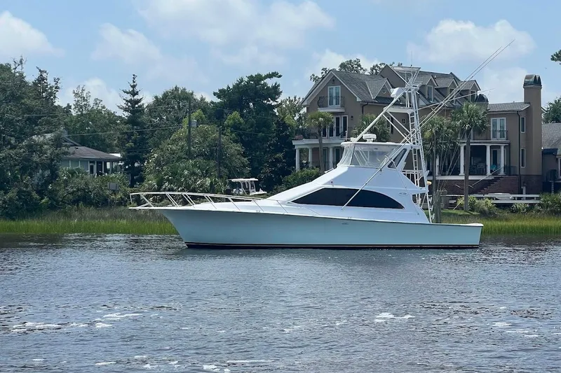 Top Pryority Yacht Photos Pics 1996 Ocean Yachts 48 Super Sport boat on calm water near luxury homes.