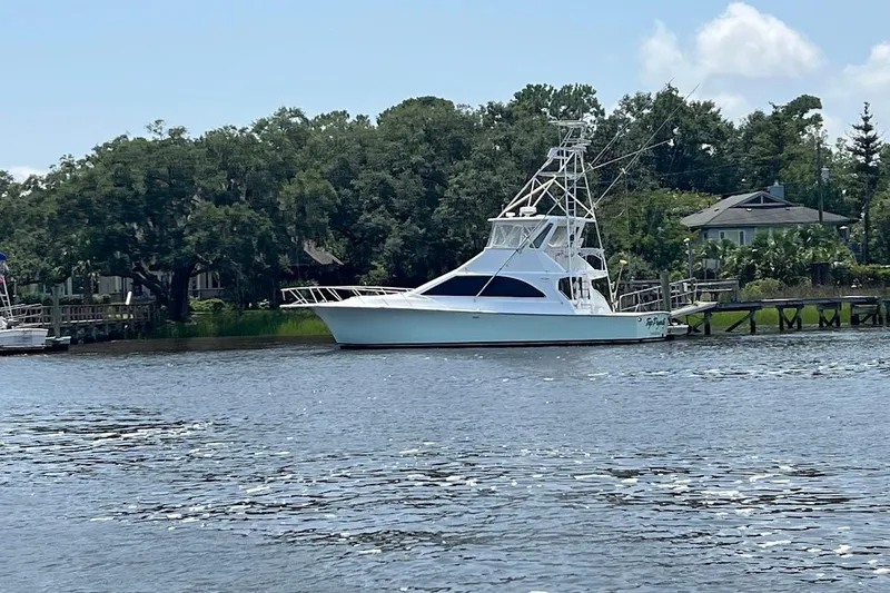 Top Pryority Yacht Photos Pics 1996 Ocean Yachts 48 Super Sport docked by a scenic riverside.