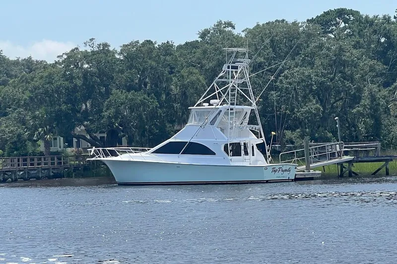 Top Pryority Yacht Photos Pics 1996 Ocean Yachts 48 Super Sport docked by lush greenery.