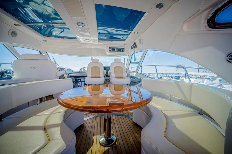 At's Ahmibote V Yacht Photos Pics Luxurious interior of 2011 Sea Ray 580 Sundancer yacht with elegant seating and wooden table.