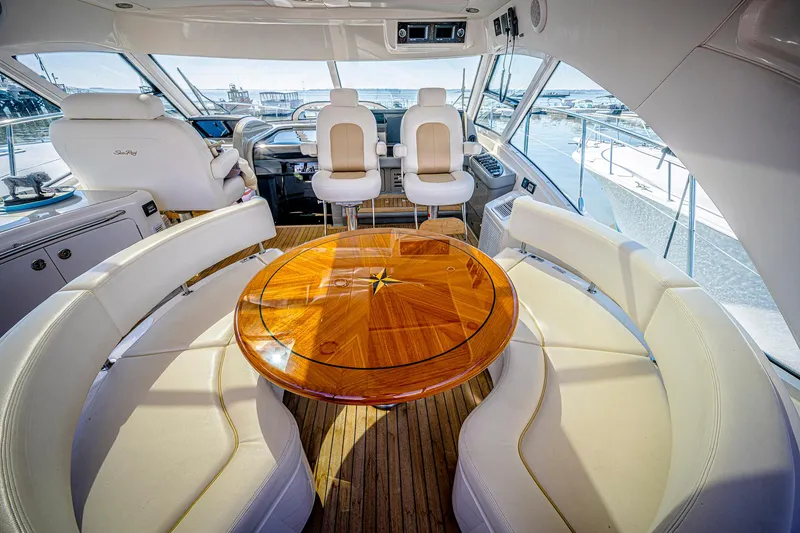 At's Ahmibote V Yacht Photos Pics Luxurious 2011 Sea Ray 580 Sundancer yacht interior with elegant seating and wooden table.