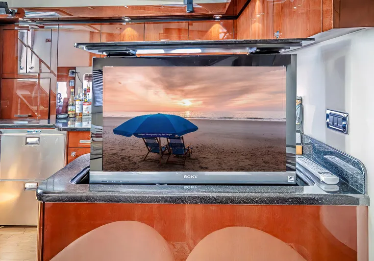 At's Ahmibote V Yacht Photos Pics 2011 Sea Ray 580 Sundancer interior with pop-up TV and beach scene.