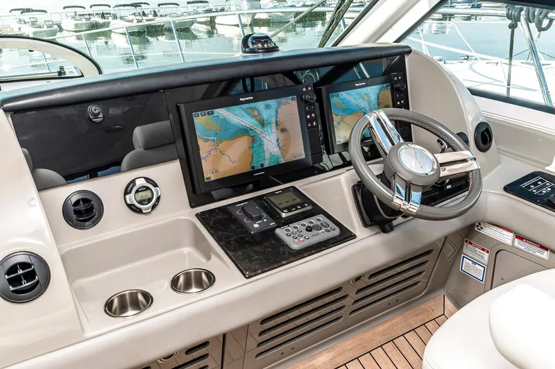 At's Ahmibote V Yacht Photos Pics Helm of 2011 Sea Ray 580 Sundancer with navigation screens and steering wheel.