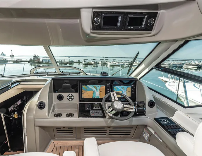 At's Ahmibote V Yacht Photos Pics Helm of 2011 Sea Ray 580 Sundancer yacht with navigation screens and steering wheel.