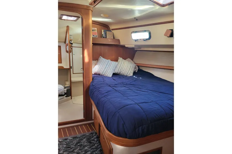 Catharpin Blue Yacht Photos Pics Cozy cabin interior of 1984 Island Packet 420 sailboat with blue bedding and wooden accents.