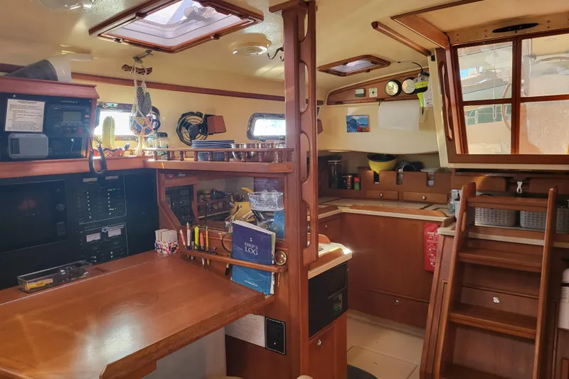 Catharpin Blue Yacht Photos Pics Interior of 1984 Island Packet 420 sailboat, featuring navigation station and galley with wooden cabinetry.