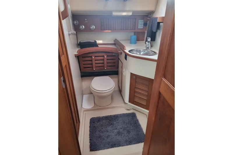 Catharpin Blue Yacht Photos Pics 1984 Island Packet 420 yacht bathroom with wooden cabinetry, sink, and toilet.