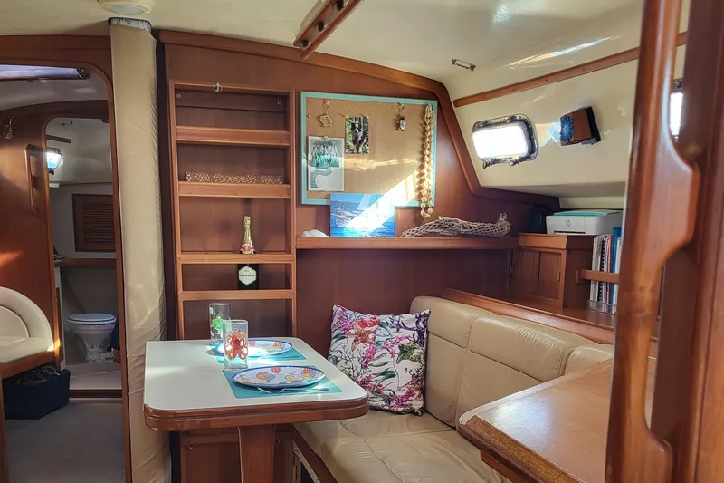 Catharpin Blue Yacht Photos Pics Interior of 1984 Island Packet 420 sailboat with cozy dining area and wooden cabinetry.