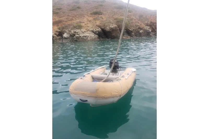 Catharpin Blue Yacht Photos Pics Inflatable dinghy floating near rocky shore, associated with 1984 Island Packet 420.
