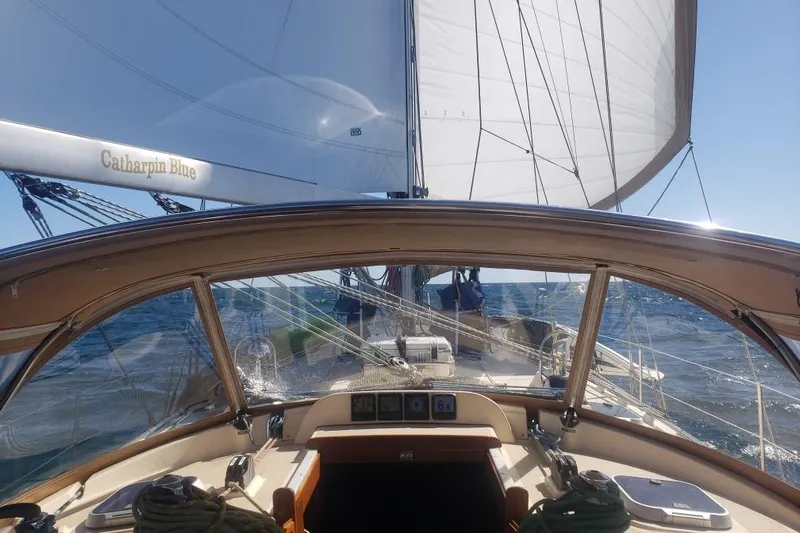 Catharpin Blue Yacht Photos Pics Cockpit view of 1984 Island Packet 420 sailboat, "Catharpin Blue," sailing on open sea.