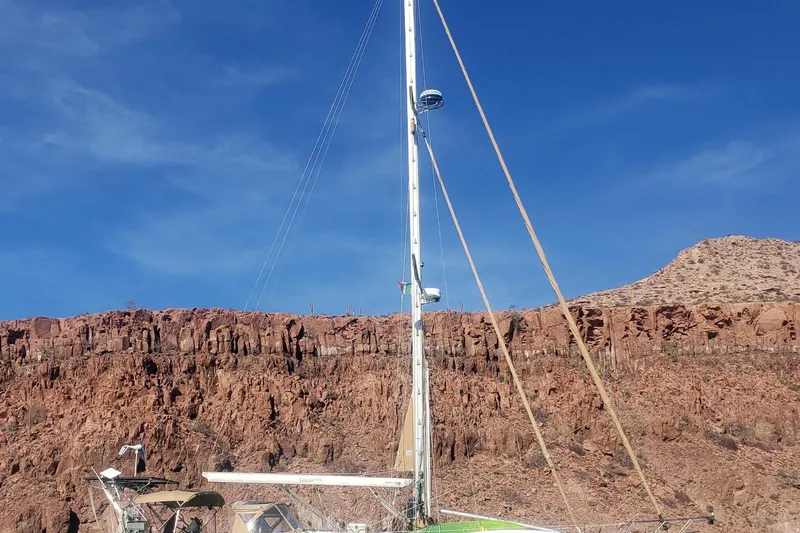 Catharpin Blue Yacht Photos Pics Sailboat Island Packet 420, 1984 model, against rocky desert landscape and clear blue sky.
