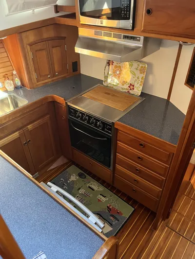 Candy O Yacht Photos Pics 1999 Sabre Sabreline 47 yacht kitchen with wooden cabinetry and modern appliances.