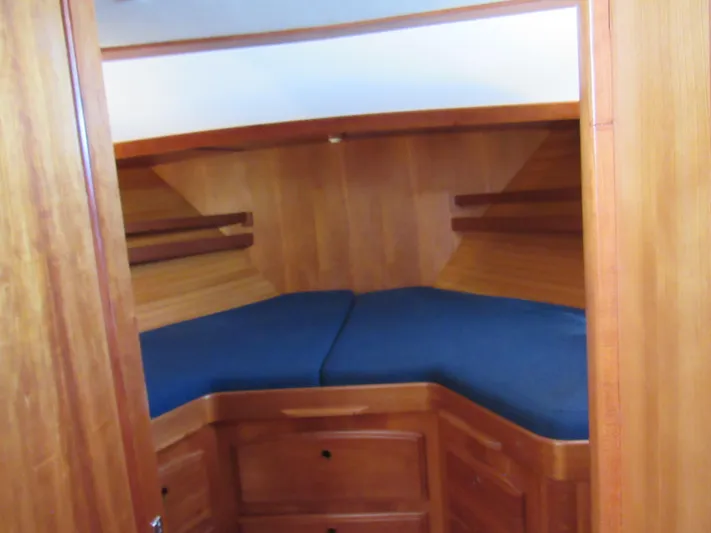 Candy O Yacht Photos Pics 1999 Sabre Sabreline 47 yacht cabin with wooden interior and blue cushions.