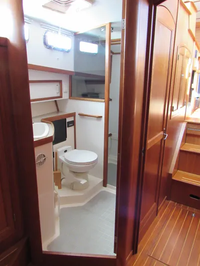 Candy O Yacht Photos Pics 1999 Sabreline 47 yacht bathroom with wooden cabinetry and modern fixtures.