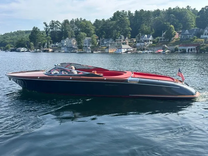  Yacht Photos Pics 2013 Riva Aquariva 33 boat cruising on a scenic lake with waterfront homes.