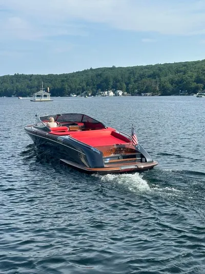  Yacht Photos Pics 2013 Riva Aquariva 33 cruising on a serene lake with lush green shoreline.