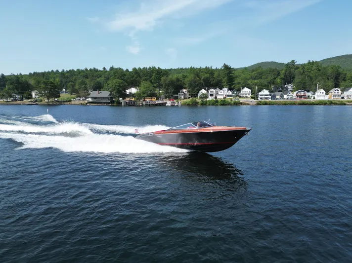 Yacht Photos Pics 2013 Riva Aquariva 33 cruising on a scenic lake with houses in the background.