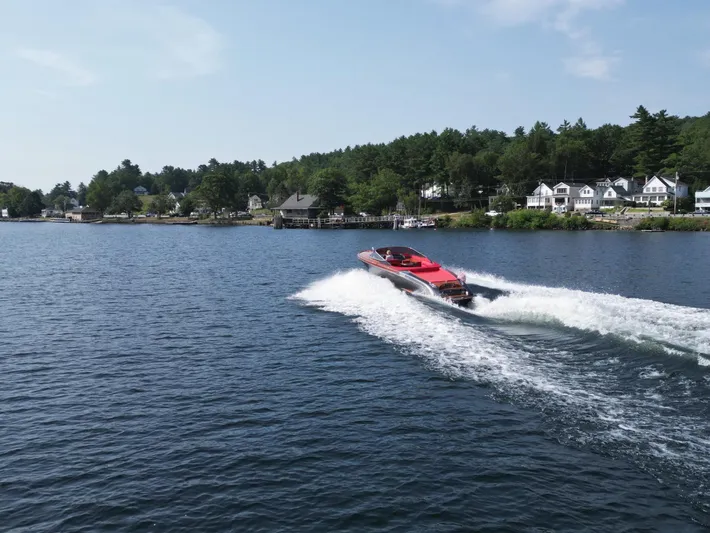  Yacht Photos Pics 2013 Riva Aquariva 33 speedboat cruising on a scenic lake with waterfront homes.