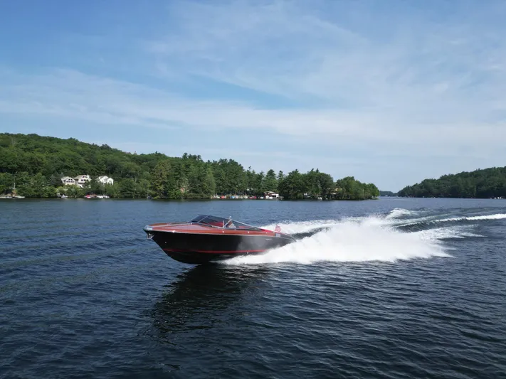  Yacht Photos Pics 2013 Riva Aquariva 33 speedboat cruising on a scenic lake with lush green shoreline.