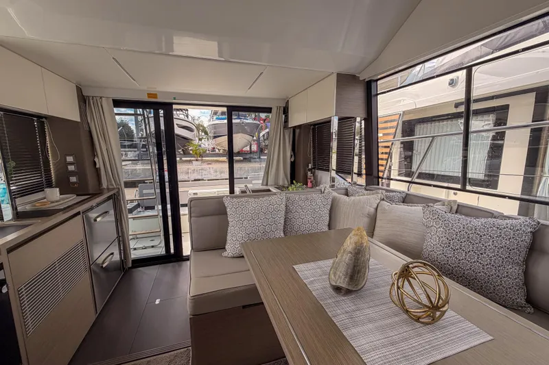 Rhapsody In Sea Yacht Photos Pics Luxurious interior of 2025 Jeanneau NC 1295 Fly yacht with modern decor and spacious seating.