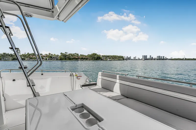 Rhapsody In Sea Yacht Photos Pics 2025 Jeanneau NC 1295 Fly yacht deck with scenic waterfront view.