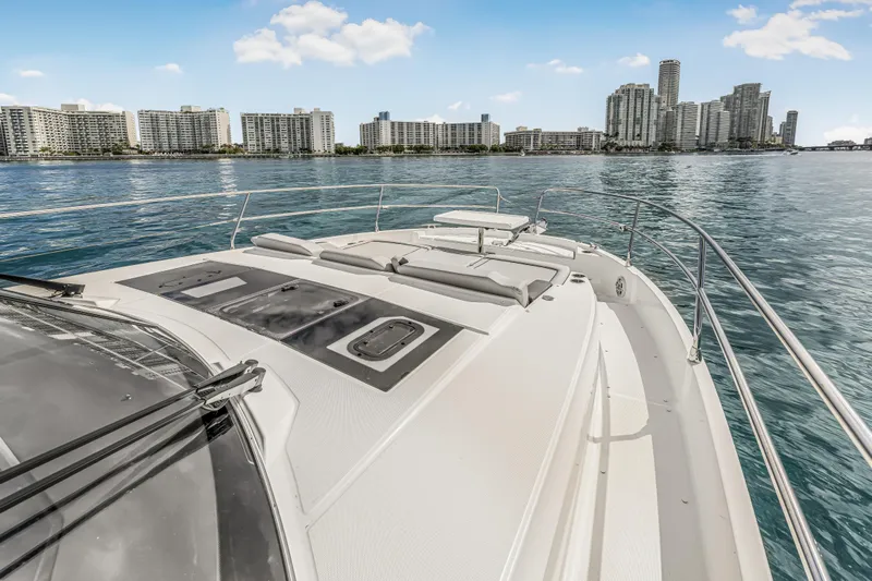 Rhapsody In Sea Yacht Photos Pics 2025 Jeanneau NC 1295 Fly yacht with city skyline in the background.