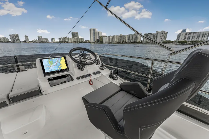 Rhapsody In Sea Yacht Photos Pics Helm of 2025 Jeanneau NC 1295 Fly yacht with city skyline view.