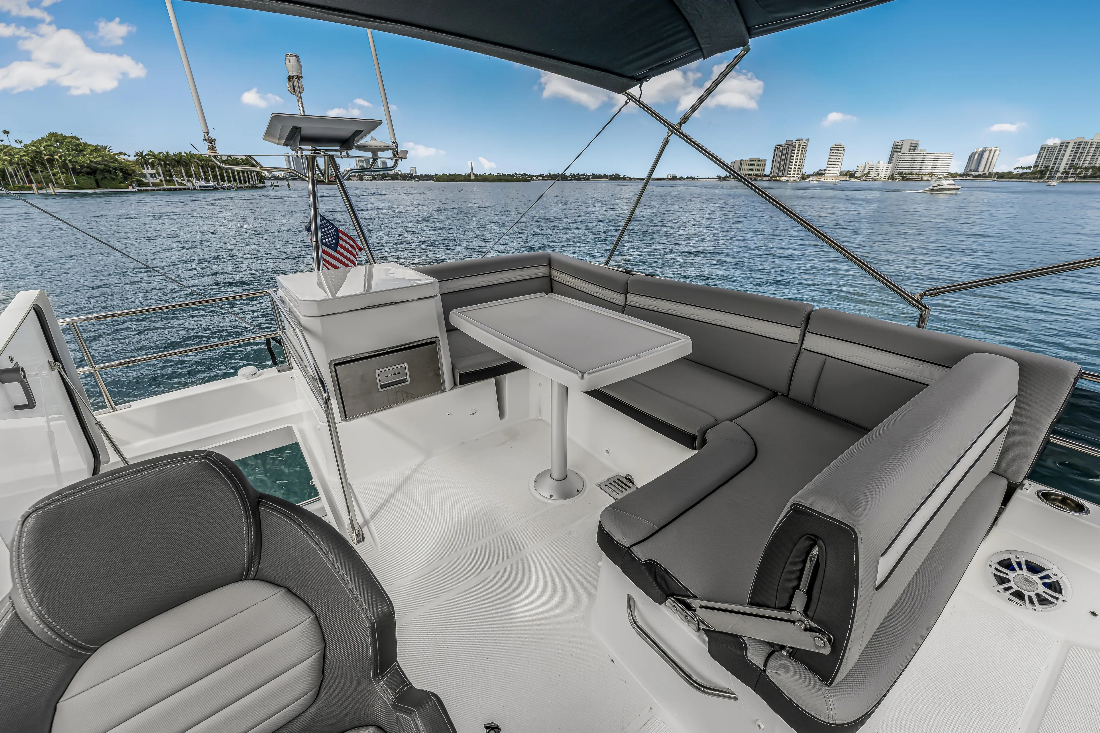 Rhapsody In Sea Yacht Photos Pics 2025 Jeanneau NC 1295 Fly yacht with elegant seating and scenic waterfront view.