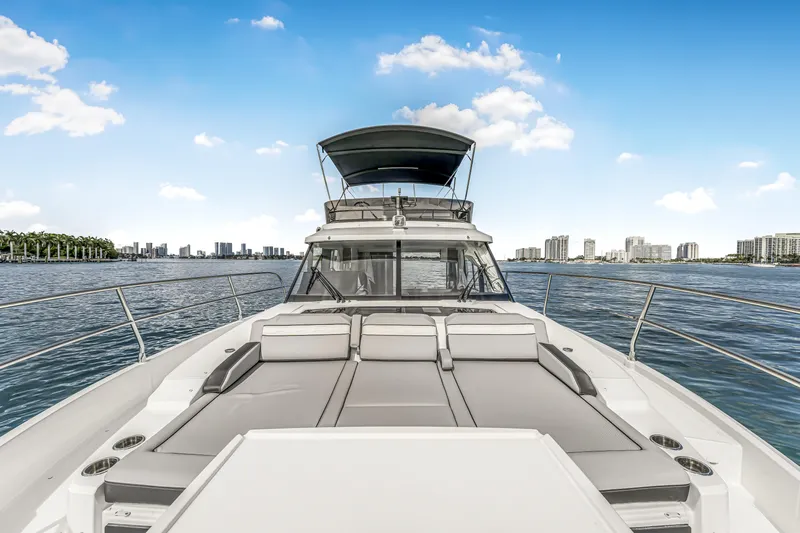 Rhapsody In Sea Yacht Photos Pics 2025 Jeanneau NC 1295 Fly yacht on water, featuring spacious deck and modern design.