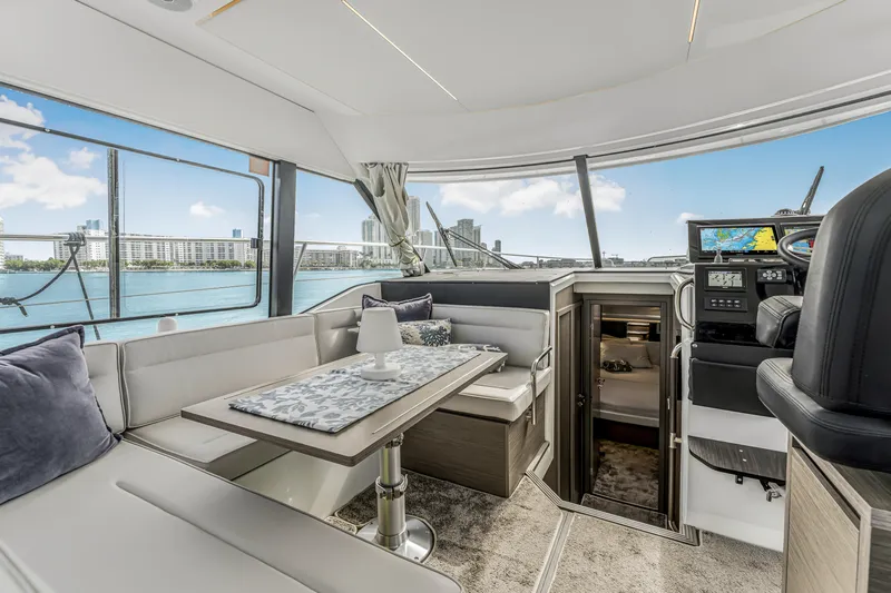 Rhapsody In Sea Yacht Photos Pics Luxurious interior of 2025 Jeanneau NC 1295 Fly yacht with city skyline view.