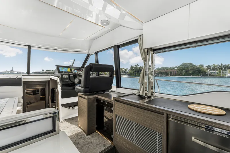 Rhapsody In Sea Yacht Photos Pics Interior of 2025 Jeanneau NC 1295 Fly yacht with modern helm and waterfront view.
