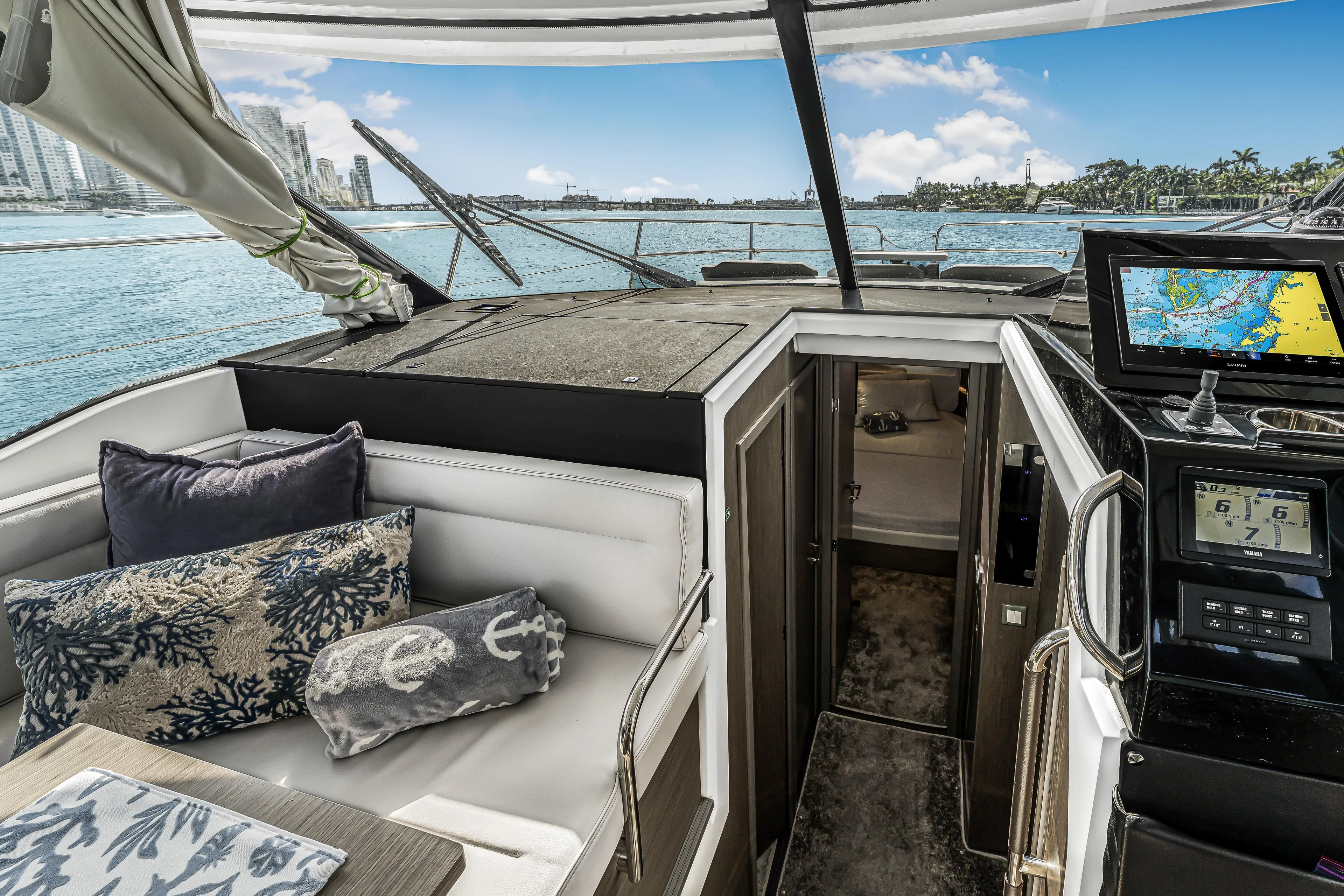 Rhapsody In Sea Yacht Photos Pics 2025 Jeanneau NC 1295 Fly yacht interior with navigation system and cozy seating area.