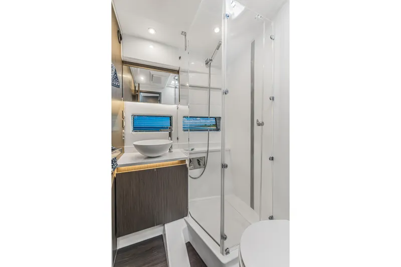 Rhapsody In Sea Yacht Photos Pics Modern bathroom interior of 2025 Jeanneau NC 1295 Fly yacht, featuring sleek design and glass shower.