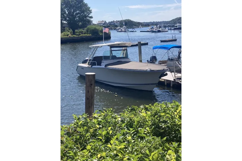  Yacht Photos Pics 2014 Pursuit ST 310 Sport boat docked in a scenic marina setting.