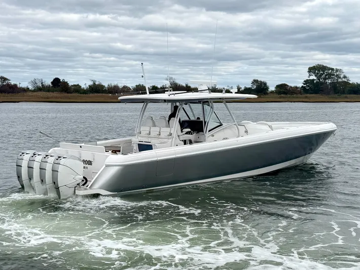Panacea Yacht Photos Pics 2019 Intrepid 475 Panacea boat cruising on a calm waterway under cloudy skies.