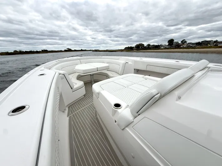 Panacea Yacht Photos Pics 2019 Intrepid 475 Panacea boat interior with white seating and table on a cloudy day.