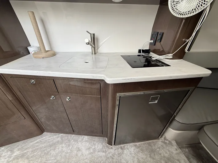 Panacea Yacht Photos Pics 2019 Intrepid 475 Panacea interior with kitchenette, featuring sink, stove, and storage cabinets.