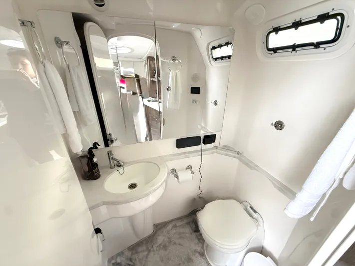 Panacea Yacht Photos Pics Luxurious bathroom interior of 2019 Intrepid 475 Panacea yacht, featuring sink, toilet, and window.
