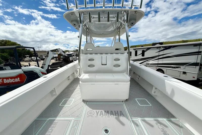  Yacht Photos Pics 2023 Contender 39 Fisharound boat interior with seating and Yamaha branding under a blue sky.